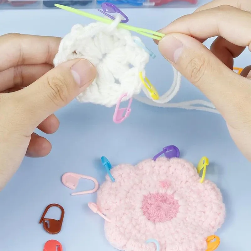Locking stitch markers clipped into a crocheted flower motif in progress