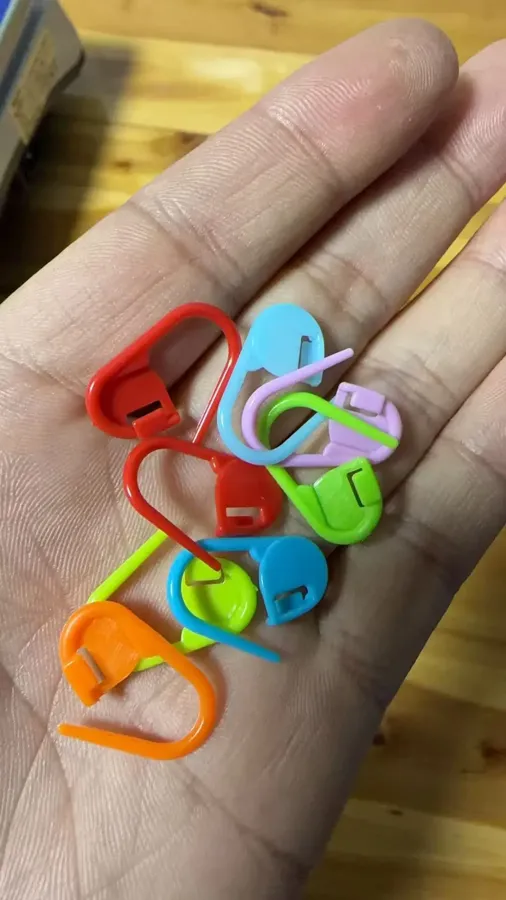 Buyer photo of colorful locking stitch markers held in an open palm